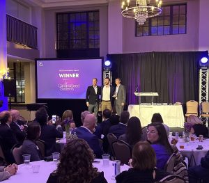 Executives with Carolina Seed Systems pose on the stage with their trophy award at the 2023 InnoVision Awards as the winner of the Sustainability Award