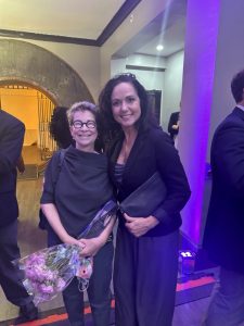 Dr. Charles Townes Individual Lifetime Achievement Award winner Amy Robichaud stands holding her award and a bouquet of flowers with Kim, Lahey & Killough Marketing Consultant Cherish Benton