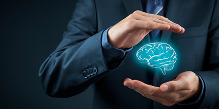 IP image of business man wearing a suit with his hands in front of him protecting a computerized graphic of a human brain